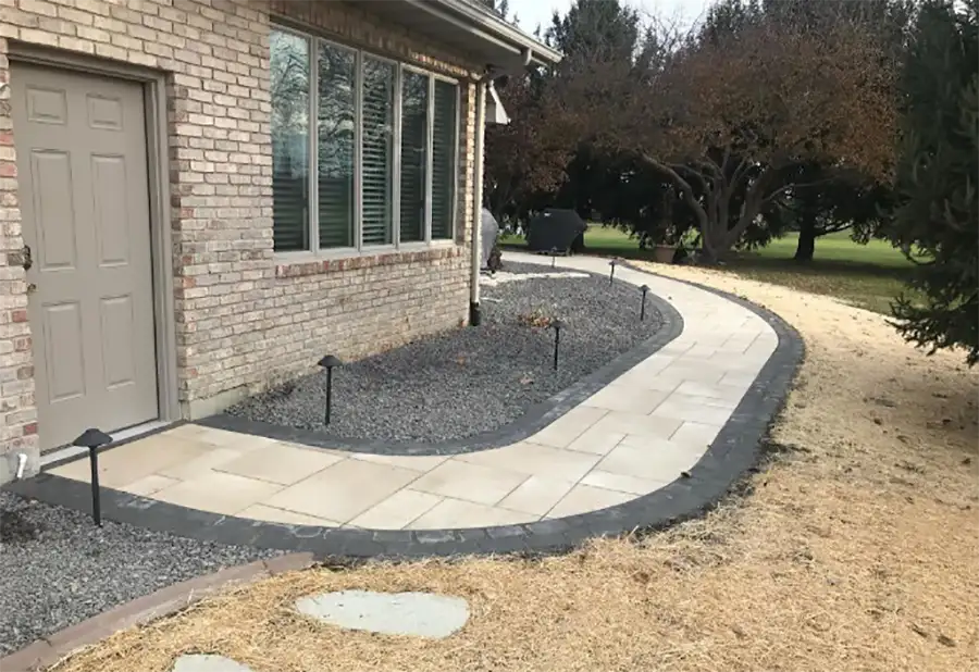 Deep Roots - Concrete Services, cut stone path leading to back patio, surrounded by brick edging and rockscaping - Chatham, IL