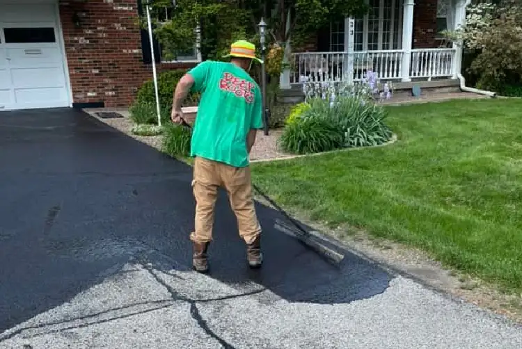 Deep Roots - worker applying asphalt seal coating for new driveway - Chatham, IL
